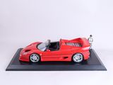 une voiture de sport Ferrari rouge posée sur un socle noir, avec un fond blanc