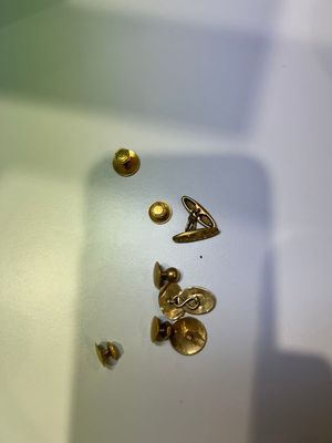 de nombreux clous dorés posés sur une surface blanche