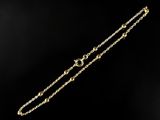 a close up of a gold chain bracelet on a black background