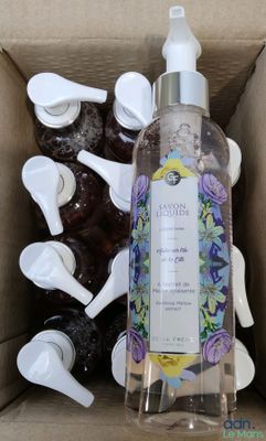 a bottle of liquid sitting inside of a box with spoons