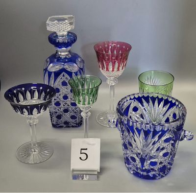 many different colored glass vases and glasses on the table