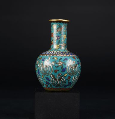 un vase bleu posé sur un socle noir, devant un fond noir
