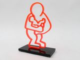 a neon sculpture of a man holding a baby in his arms