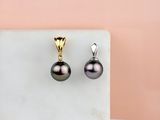 une photo d'une paire de boucles d'oreilles en perles noires posées sur une surface en marbre
