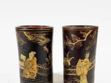 pair of black and gold vases with asian scenes on them