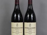two bottles of wine sitting on top of a table next to each other