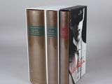 two books are stacked on top of each other on a gray surface