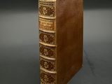 an old book sitting on top of a table next to a black background