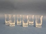 four shot glasses are lined up on a blue surface