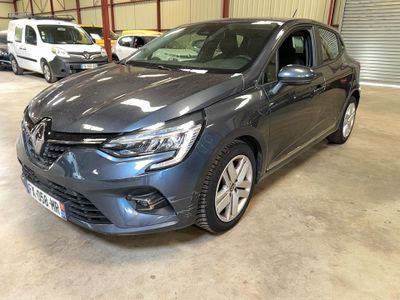 une voiture grise garée dans un garage, avec d'autres voitures en arrière-plan