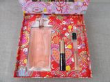 a pink box with a perfume and a lipstick in it
