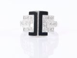a close up of a diamond and onyxine ring on a white surface