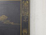 a black book with gold trim on a white wall
