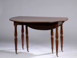 une table ovale avec des pieds tournés et un plateau rabattable