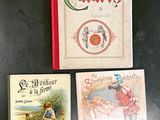 three children ' s books sitting on a black table