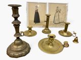 a group of brass candlesticks and a picture of a woman