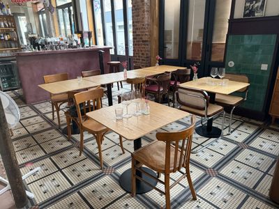 des tables et des chaises dans un restaurant, avec un ventilateur en arrière-plan