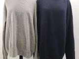 deux pulls posés sur un mannequin se trouvent devant un mur blanc