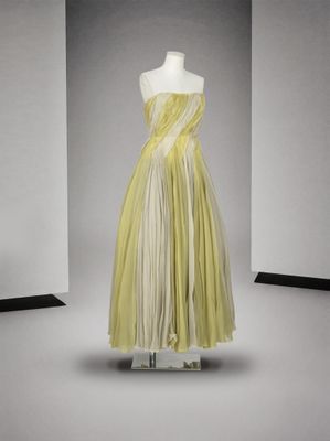 une photo d'une robe jaune et blanche posée sur un présentoir pour mannequin