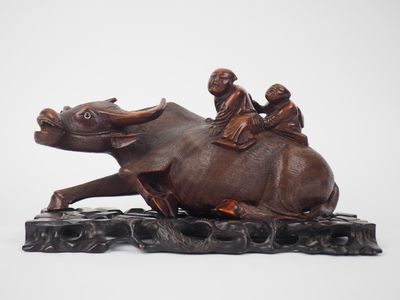 une statue représentant un homme chevauchant un éléphant avec deux enfants sur le dos