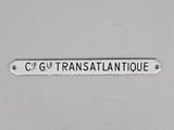 une affiche accrochée au mur sur laquelle on peut lire « c'est transatlantique »