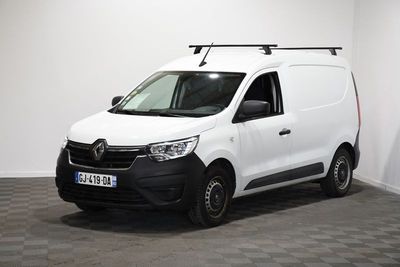 la camionnette blanche est garée dans une pièce au sol en damier