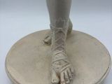 sculpture of a woman ' s feet on a pedestal with a white background