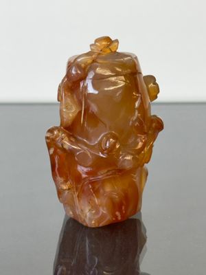 une petite statue représentant un homme assis sur un rocher