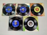 four vinyl records sitting on top of each other on top of a table