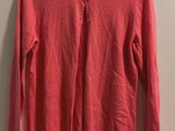 un pull rouge suspendu à un cintre contre un mur