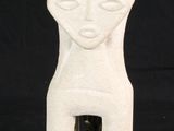 a white ceramic sculpture of a woman ' s face on a black background