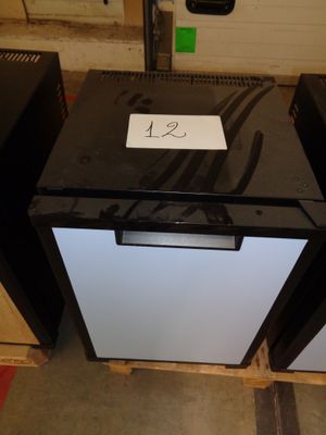 two black and white refrigerators sitting in a room