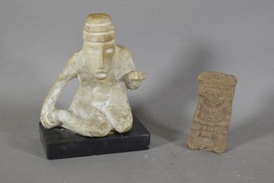 une petite statue représentant un homme assis à côté d'une autre petite statue représentant un homme