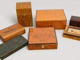 plusieurs types de boîtes et de coffrets en bois posés sur une surface blanche