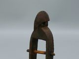 une vieille figurine en bois représentant un homme avec un chapeau sur la tête