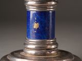 a silver candle holder with a blue stone on it