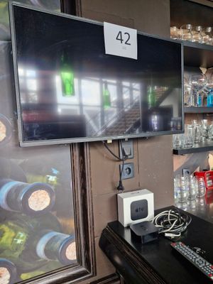 a television that is sitting on a table in front of a refrigerator