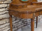 a small wooden table with a mirror on top of it