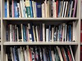 a book shelf with many books on it in a room
