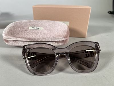 sunglasses and case on a table next to a pair of glasses