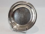 a silver plate on a stand on a white surface