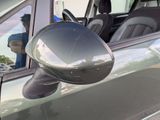 a reflection of a man in the side mirror of a car