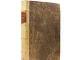 an old book sitting on top of a white surface