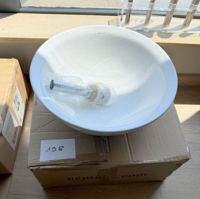 un bol blanc posé sur une boîte près d'une fenêtre