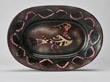 a black and red plate with a bird on it