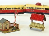 un petit train miniature posé à côté d'une petite maison