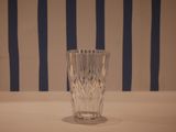a glass that is sitting on a table in front of a striped wall