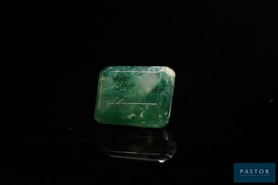 une photo d'un morceau de jade vert posé sur une surface noire
