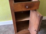 a wooden cabinet with a marble top and a door open