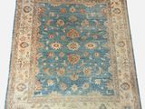 a blue and beige rug on a white background